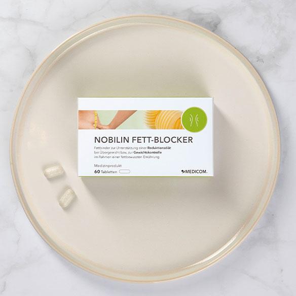 Die Produktpackung Nobilin Fett-Blocker auf einem Teller mit 2 Tabletten